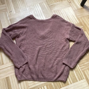 Rosa stickad v-ringad tröja NA-KD - Mysig stickad tröja från NA-KD i en dämpad rosa nyans. Tröjan har v-ringning där bak, lång ärm och ribbade muddar. Perfekt för lager-på-lager och chill dagar. Passar dig som gillar enkel men snygg stil.