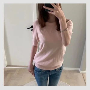 Ljusrosa stickad tröja med kort ärm - Supersöt ljusrosa stickad tröja med korta ärmar och rund hals. Perfekt till jeans eller kjol för en chill och fräsch look. Mjuk och skön, passar perfekt till våren och sommaren.