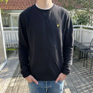 Lyle & Scott tröja  - Svart sweatshirt från Lyle & Scott. Tröjan har ribbade muddar vid ärmslut och nederkant samt långärmad passform. Perfekt för dig som gillar enkel och stilren design, passar till vardag o finare tillfällen! 