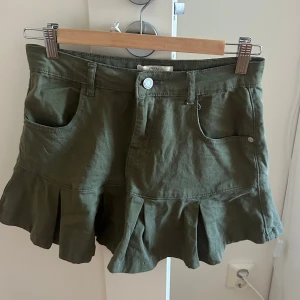 Olivgrön volangkjol - Snygg olivgrön kortkjol med volangkant från Don't Think Twice.  