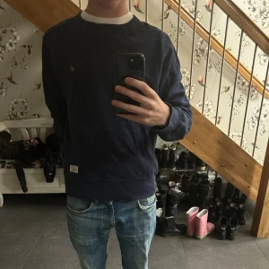 Mörkblå sweatshirt från True Religion - Säljer en mörkblå sweatshirt från True Religion i storlek XLmen är krympt till en small. Tröjan har klassisk passform med rund hals och långa ärmar. Tillverkad i mjuk bomull, perfekt för en avslappnad och stilren look. Diskret logga på bröstet och ribbade muddar.