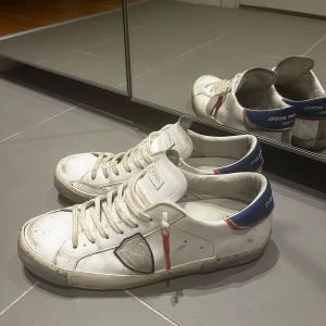 Philippe Model vita sneakers med blå detalj - Tjena! Säljer nu mina philippe modell skor som köptes sprillans nya från en butik i Göteborg. Låda fås med vid köp📦. Säljer då jag inte använder skorna längre. Storlek 43 men passar även dig som har storlek 44!✅skorna är o bra skick skulle bara behöva tvättas men sänker priset istället då jag inte har intresse för dessa skor längre. Skriv vid mer info eller bilder👌🏼