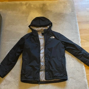 North face jacka - Den är använd mycket och har tagit bild där den är  skadad annars är den jätte bra värmer och tållregn och vind
