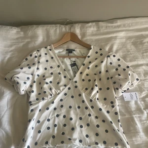 Prickig satin blus Bubbleroom - Aldrig använd då den var för liten, alla lappar finns kvar.   Strl 46 men den är väldigt liten o storlek så är mer än 38!/M mått kan fås vid önskan!