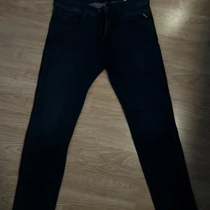 Replay Anbass mörkblå jeans W33 L32 - Snygga mörkblå Replay Anbass jeans i slim fit med klassisk femficksdesign. Jeansen har en stilren look med smal passform och är tillverkade i stretchigt denim för extra komfort. Perfekta för dig som gillar en modern och clean stil. De är helt oanvända bara provade i butik och sedan köpta. Nypris 1899kr!
