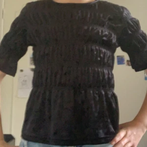 Svart sammetsblus från Lindex - Säljer en svart sammetsblus från Lindex med snygga rynkade detaljer över hela toppen. Blusen har rund halsringning och halvlånga ärmar som ger en cool och trendig look. Perfekt att styla med jeans eller kjol för en chic outfit. Priset kan diskuteras och om mer bilder önskas så är det bara att säga till💗