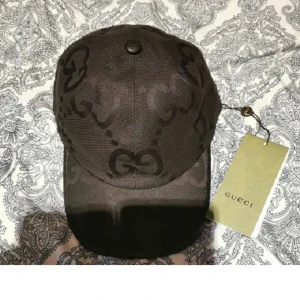 Gucci Keps - Snygg svart keps från Gucci med det klassiska GG-monogrammet ton-i-ton över hela kepsen. Kepsen har böjd skärm och justerbar baksida. Tillverkad i ett slitstarkt tyg med märkets logga på insidan och etikett som visar att den är gjord i Italien.