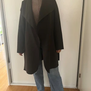 Mörkgrå kappa från Vila med bälte - Säljer en mörkgrå kappa från Vila i storlek S. Stor krage och skärp. Nyskick, kom gärna med bud.