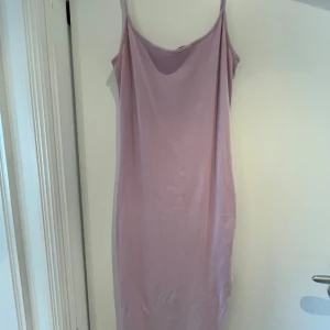 Ljuslila ribbad klänning Amisu - Klänning från Amisu i en ljuslila nyans. Klänningen är ribbad, har smala axelband och är figurnära med en enkel, stilren design. Den har även en slits på vänster ben. 