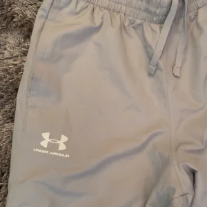 Under armour byxor, grå - Bra skick, liiitet hål på baksidan men inget man märker  Snygga och sällsynta  Straight leg så de har en fin passform Storlek M
