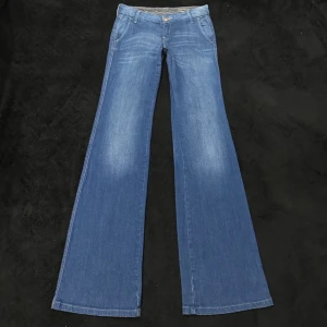 Blå bootcut jeans med vida ben - Snygga blå jeans med klassisk bootcut och vida ben. Jeansen har fem fickor, bälteshällor och stängs med knapp och dragkedja. Tillverkade i mjukt denimtyg som ger en skön känsla och cool look. De är lågmidjade. Måtten syns på bilden, skriv för frågor och innan du köper! De är tyvärr alldeles för små för mig så kan inte skicka bild med dem på. Grenhöjden är 18cm