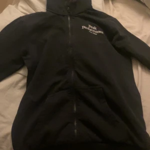 Svart kofta  från Peak Performance - Svart kofta från Peak Performance  med dragkedja framtill och huva. . Perfekt för dig som gillar en enkel och stilren look.