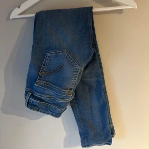 Blå skinny jeans Monroe - Snygga blå skinny jeans från Monroe med klassisk femficksdesign och kontrastsömmar. Jeansen har en smal passform och är tillverkade i mjukt denimtyg som sitter tajt längs benen. Perfekta för dig som gillar en modern och stilren look.