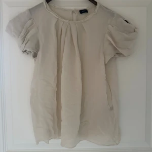 Beige blus med puffärm från Joseph - Säljer en söt beige blus från Joseph med korta puffärmar och rund halsringning. ❤️❤️