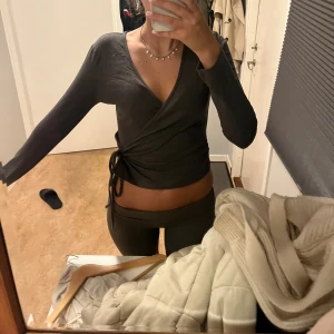 Mörkgrå omlottopp från Gina Tricot - Säljer en mörkgrå omlottopp från Gina Tricot i storlek M. Verkligen jätte nice till varje outfit 