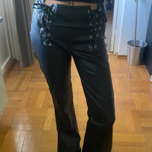 Läder byxor - svarta byxor med skinnimitation från Bershka med höga snörningsdetaljer i midjan. Byxorna har bootcut-modell.