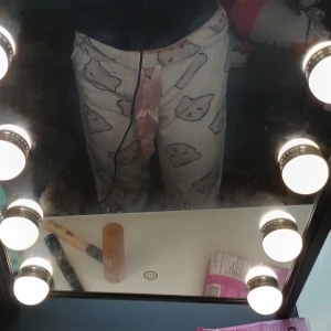 Vita mjukisbyxor med kattmönster - Supermysiga vita mjukisbyxor med söta kattansikten över hela byxorna och en rosa snörning i midjan. Perfekta för chill dagar hemma. Byxorna är i ett mjukt material och har en relaxed fit.