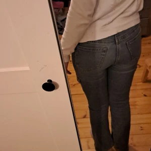 Blå jeans från Lindex med fickor på sidorna - Säljer ett par blå jeans från Lindex med bootcut form och praktiska fickor på sidorna. Jeansen har en bootcut passform och är tillverkade i mjukt jeanstyg. Perfekta för en avslappnad och cool stil.