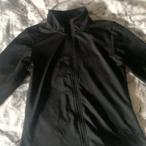 Svart träningsjacka  - Svart träningsjacka från Iconic med hög krage och hel dragkedja framtill. Väldigt skönt material men den passar inte mig längre 🤍 