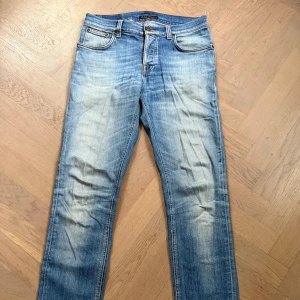 Nudie Jeans Grim Tim 31/34 - Grim Tim Orange Cloud från Nudie Jeans med klassisk femficksdesign och snygga slitningar. Bra skick