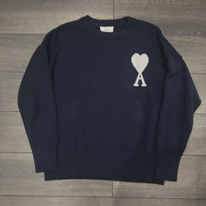 Mörkblå stickad tröja från Ami Paris - Mörkblå stickad tröja från Ami Paris. Tröjan är i väldig bra skick då den endast är använd ett fåtal gånger. Den är i storlek M och passar på mig som är ca180. Skriv gärna vi frågor, priset är inte hugget i sten.