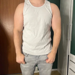 Vit linnetopp från JC - Säljer en klassisk vit linnetopp från JC i storlek L. Toppen är ärmlös med rund halsringning och tillverkad i mjuk bomull, perfekt för en avslappnad och enkel stil. Passar lika bra till jeans som shorts.
