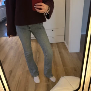 Bootcut jeans från Gina tricot - Snygga ljusblå bootcut jeans från Gina tricot i storlek 32. Klassisk femficksmodell med broderade detaljer på bakfickorna. Jeansen har normal passform och är tillverkade i ett mjukt denimtyg som sitter skönt hela dagen. Är bra i längd för mig som är ca 170 cm lång. Använda 1 gång