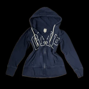 Marinblå zipup från GAP - Snygg marinblå ziup hoodie från GAP, har en liten fläck på snöret (man kan såklart byta snörre). Storlek S Bud tas emot! Skickar inom 1-2dagar. Lagt ut på Vinted också där många är intresserade så passa på!! Kolla in mina andra plagg också!!(: