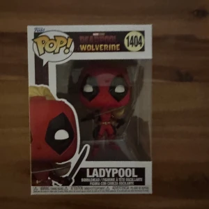 Funko Pop! Marvel Deadpool & Wolverine Ladypool #1404 - Funko Pop! Ladypool #1404 från Marvel Deadpool & Wolverine-serien. Figuren är ny och oöppnad i originalförpackning, perfekt för samlare. Kartongen är i mycket gott skick utan synliga skador eller slitage.