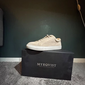 Beige mockasneakers från Myrqvist - Snygga beige sneakers från Myrqvist i mjuk mocka med vit platt sula och klassisk snörning. Perfekta för dig som gillar stilrena och minimalistiska skor med en modern touch. Passar till det mesta och är riktigt bekväma att ha på sig.