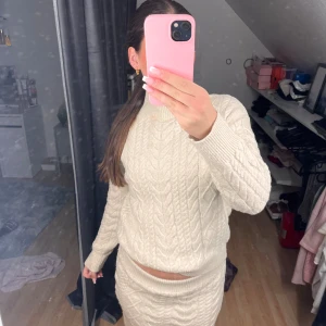 Beige stickat sett - Säljer ett beiget stickat sett. Perfekt inför hösten. Tröja storlek: 34. Kjolen: storlek 36