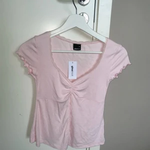 rosa top från gina tricot - aldrig använd, helt ny. har till och med prislappen kvar. den är öppen i magen och har spetsdetaljer. denna finns inte att köpa på ginas hemsida längre. pris går att diskutera!