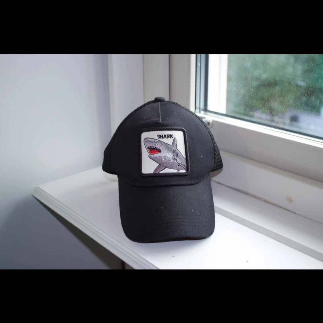 Svart keps med hajmotiv