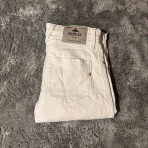 Vita Replay Anbass jeans slim fit 32/32 - Snygga vita jeans från Replay, modell Anbass med slim fit. Klassisk femficksdesign, normal midja och raka ben. Tillverkade i bomull för en skön känsla och stilren look. Perfekta för dig som vill ha ett fräscht och modernt par jeans.