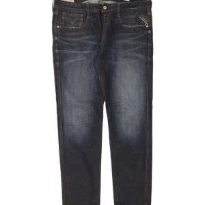 Replay Anbass jeans mörkblå herr - Snygga Replay Anbass jeans i mörkblå tvätt med klassiska fem fickor och kontrastsömmar. Jeansen har en rak passform och subtilall. Perfekta för dig som gillar en stilren och modern look.