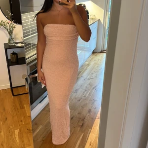 Ljusrosa axelbandslös långklänning - Superfin ljusrosa axelbandslös långklänning med glittrig yta som kommer från OhPolly som endast är använd 1 kväll. Storlek 14 men insydd hos skräddare.🩷