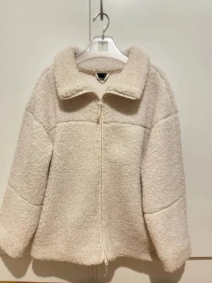 Beige teddyjacka från Gina Tricot - Säljer en beige teddyjacka från Gina Tricot i storlek M. Jackan har en mjuk och fluffig yta, dragkedja framtill och stor krage. Perfekt för dig som vill ha en mysig och trendig look under kyliga dagar.