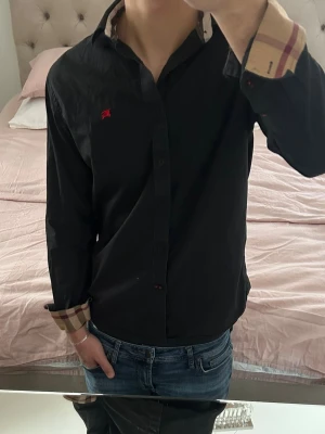 Svart Burberry skjorta  - Hej! Säljer en svart Burberry skjorta från Farfetch. Storlek S/ modellen är 1.80. Haft den i ett tag men är i fint skick( inga defekter) kvitto tillkommer/ DMa💥