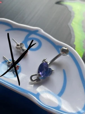  Hjärtnavelpiercing  - Lilan navelpiercing i silverfärg med ett lila hjärta och små horn 30kr.  Enbart testat och rengjorts noga.. Frågor? kom DM! kan skicka utan spårbart för 22kr frakt!