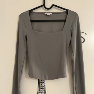 Grå långärmad topp från New Yorker  - Snygg grå långärmad topp med fyrkantig halsringning från New Yorker i storlek S. Aldrig använd. 