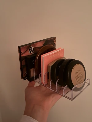 Transparent sminkförvaring i akryl - Säljer en transparent sminkförvaring i akryl med sex fack, perfekt för att organisera puder, bronzer, rouge och ögonskuggspaletter. Stilren och enkel design som passar på alla sminkbord och gör det lätt att hålla ordning på dina favoriter.