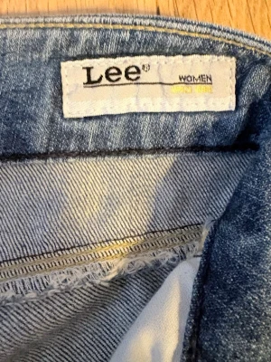  Lee jeans  - Säljer ett par ljusblå jeans från Lee med klassisk femficksmodell och raka ben och låg midja Jag är 1,62 cm lång