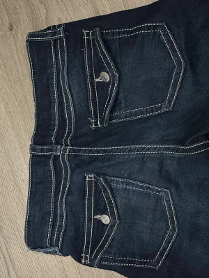 Mörkblå jeans från Gina Tricot - Mörkblå jeans från Gina tricot med knappdetaljer bak och andvänts en gång. 