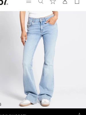 Bootcut ljusblå jeans  - Snygga ljusblå bootcut jeans från lager 157 med klassisk femficksmodell och låg midja. Jeansen har en riktigt skön passform och är tillverkade i mjukt denimtyg. Jeansen är lite slitna längst ner vid foten men inget man ser när man använder dom. Detta är den långa modellen. 