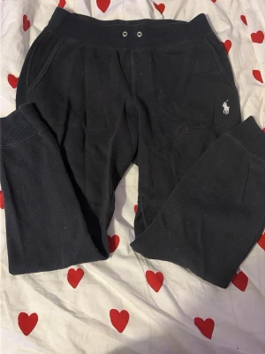 Svarta mjukisbyxor Polo Ralph Lauren - Svarta mjukisbyxor från Polo Ralph Lauren med broderad logga i vitt på vänster ben. Byxorna har resår i midjan och benslut samt fickor på sidorna. De är använda men utan några defekter!
