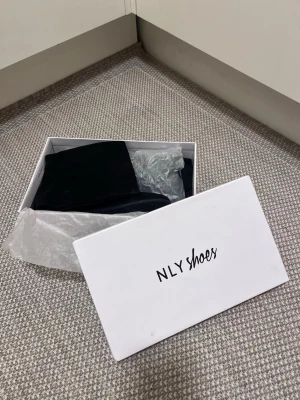 Svarta overknee boots i mocka  - Overknee stövlar från NLY Shoes i svart mocka. Stövlarna har platt sula, rund tå och snörning upptill för att sitta perfekt på benet. Storlek: 37 (smala). Mycket bra skick! Säljs på flera sidor, först till kvarn. 