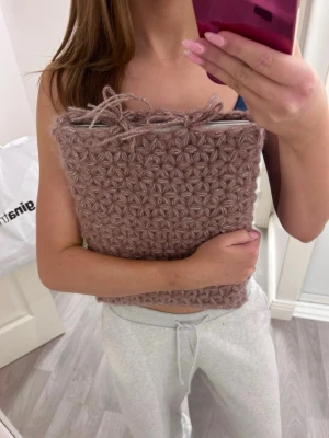 Virkat rosa datorfodral - Unik virkad datorväska i ljusrosa med blommigt mönster och snörning upptill. Handgjord! Passar en dator som är 22x32 ungefär. Funkar både med lite mindre och lite större då den är stretchig. 