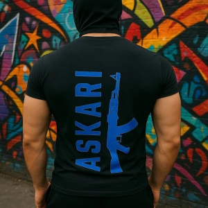 Svart ASKARI t-shirt med blått tryck - Svart t-shirt från ASKARI med stort blått tryck av texten 'ASKARI' och en gevärsgrafik på ryggen. På bröstet finns en mindre blå logga med samma motiv. T-shirten är kortärmad och har en normal passform, tillverkad i mjuk bomull.