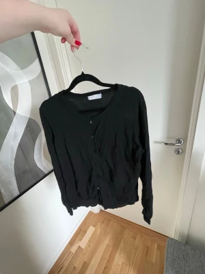 Svart kofta  - En enkel svart kofta från Primark i storlek L. Koftan har långa ärmar och knappar framtill 