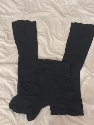 Marinblåa yoga pants - Säljer ett par marinblåa leggings från 157 i storlek XXS. De har en låg midja och är tillverkade i mjukt stretchigt material som sitter tight mot kroppen. Perfekta för en chill och enkel stil.